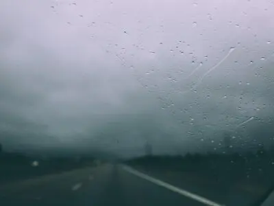 rainy thunderstorm view through a windshield