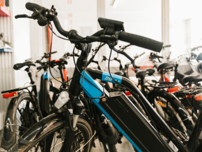 Row of electric bicycles with visible batteries parked indoors, illustrating e-bike use and safety considerations.