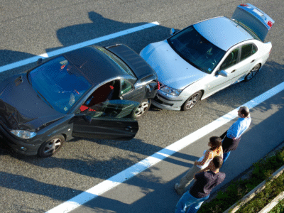 Two cars are stopped on a highway shoulder after a rear-end collision, with visible bumper damage and open doors. The drivers and passengers stand nearby examining the scene. The image highlights how even low-speed rear-end crashes in Santa Barbara can cause serious injuries like whiplash and spinal strain, underscoring the need for medical documentation and legal guidance when pursuing compensation.
