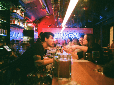 Bar patrons interact with a bartender inside a busy restaurant or nightclub, illustrating alcohol service, potential overserving, surveillance footage, cellphone video evidence, and other evidence that may support a Santa Barbara dram shop or California liquor liability claim following an alcohol-related injury.