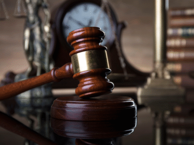A judge's gavel rests on its sound block in a courtroom setting, with scales of justice and a courthouse clock blurred in the background. The image represents wrongful death litigation, legal proceedings, and the process of filing a wrongful death claim in Ventura, California, after the unexpected loss of a loved one.