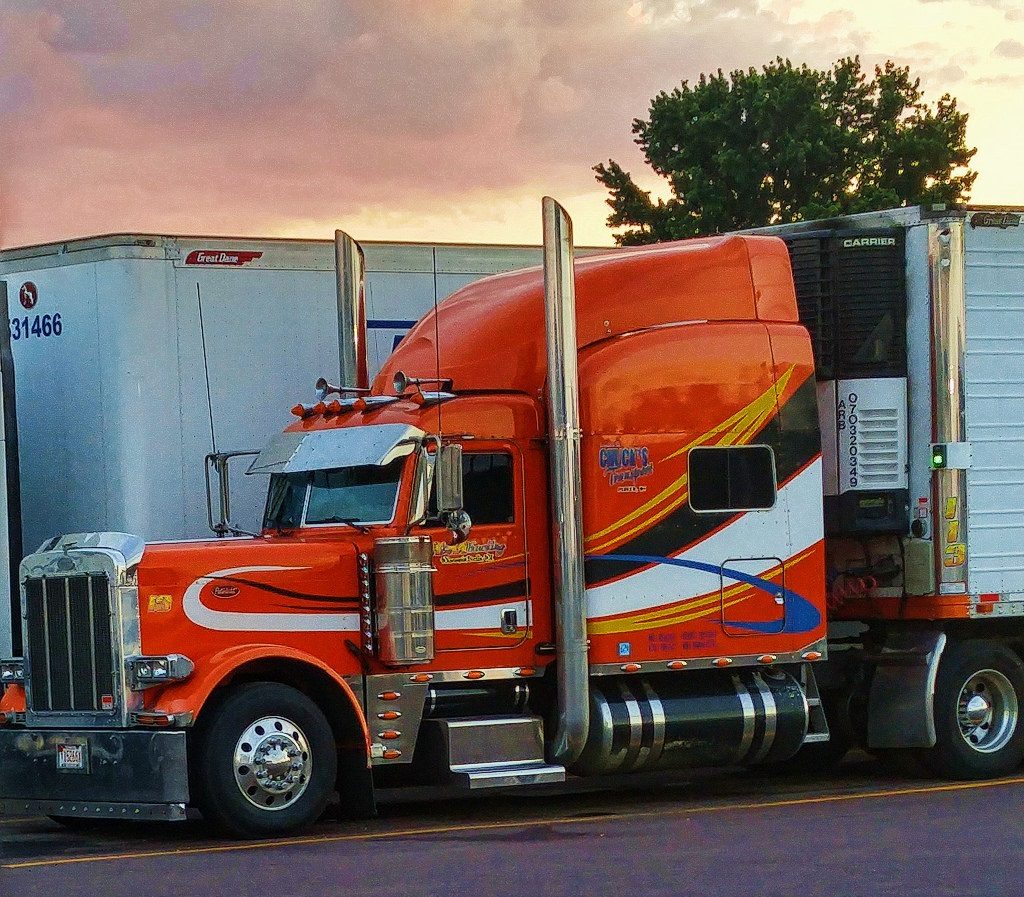 parked red semi with sunset in the background