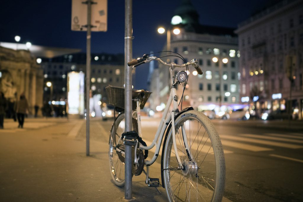 bicycle chained to a post at night