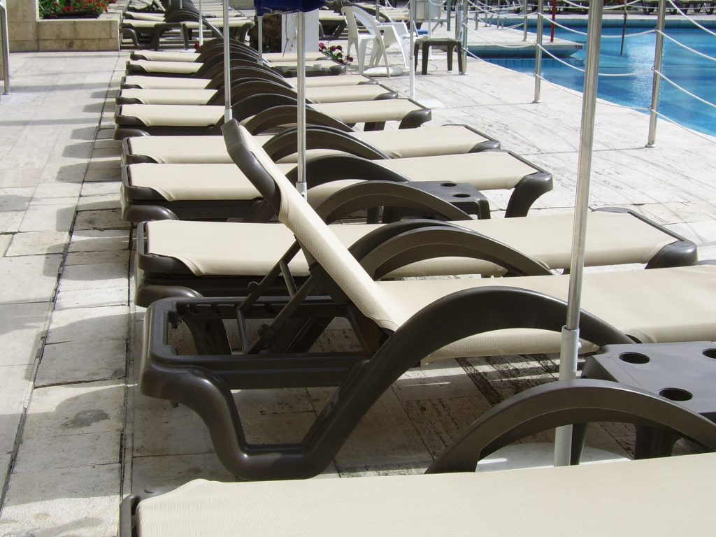 rows of lounge chairs at a pool