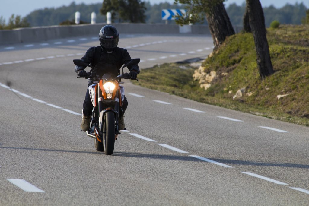 biker driving motorcycle down the street