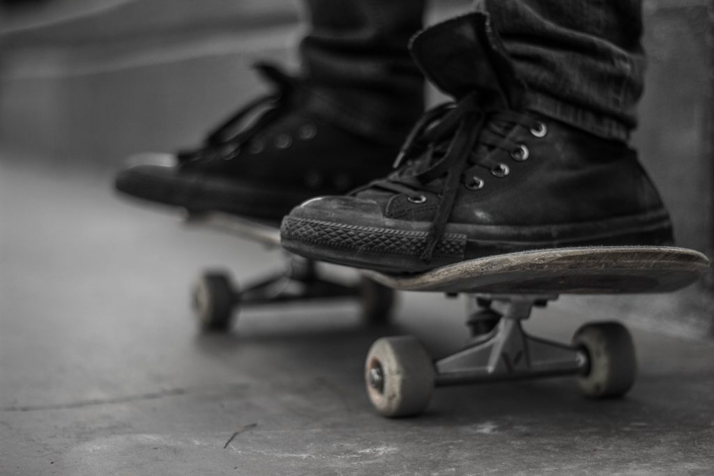 two black tennis shoes on a skateboard