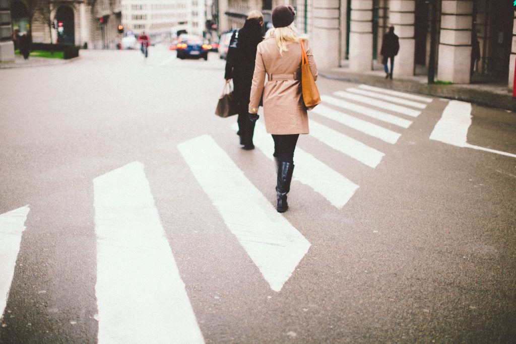 two people walking on a crosswalk