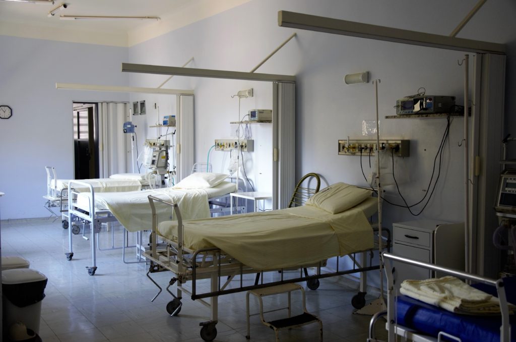 an empty hospital wing with beds and medical machines