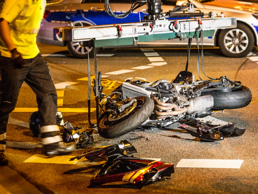 A motorcycle on the ground in an intersection after an accident.