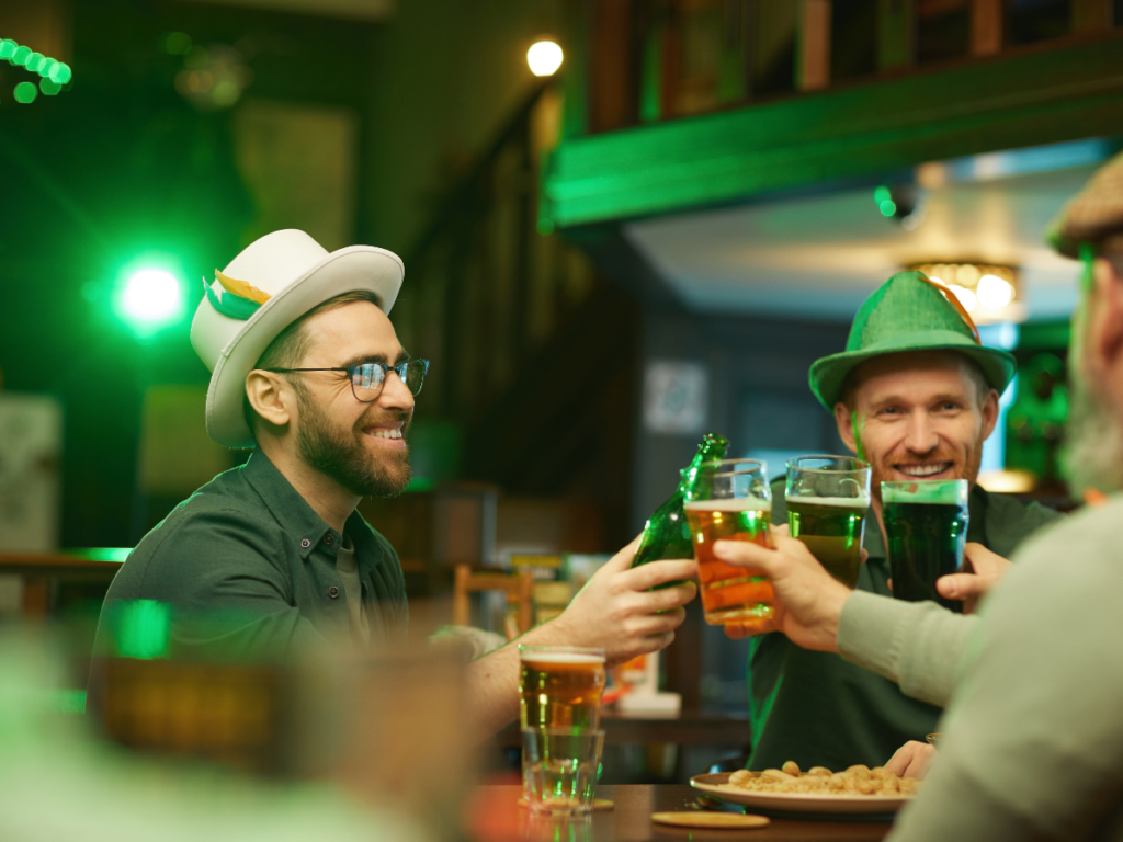 Men in green hats drinking in a bar. Saint Patricks day celebration.